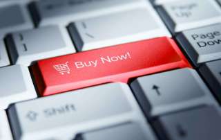 Red 'buy now!' button on a computer keyboard.