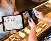 a person holding a tablet in front of a display case