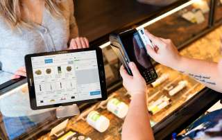 a person holding a tablet in front of a display case
