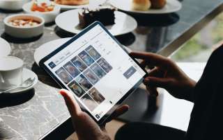 A person sitting at a table with a tablet