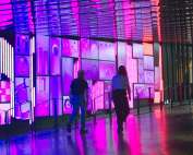 a group of people walking down a walkway next to a building