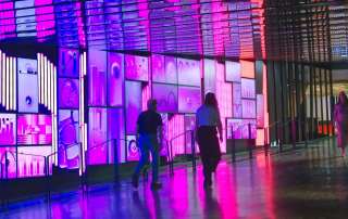 a group of people walking down a walkway next to a building